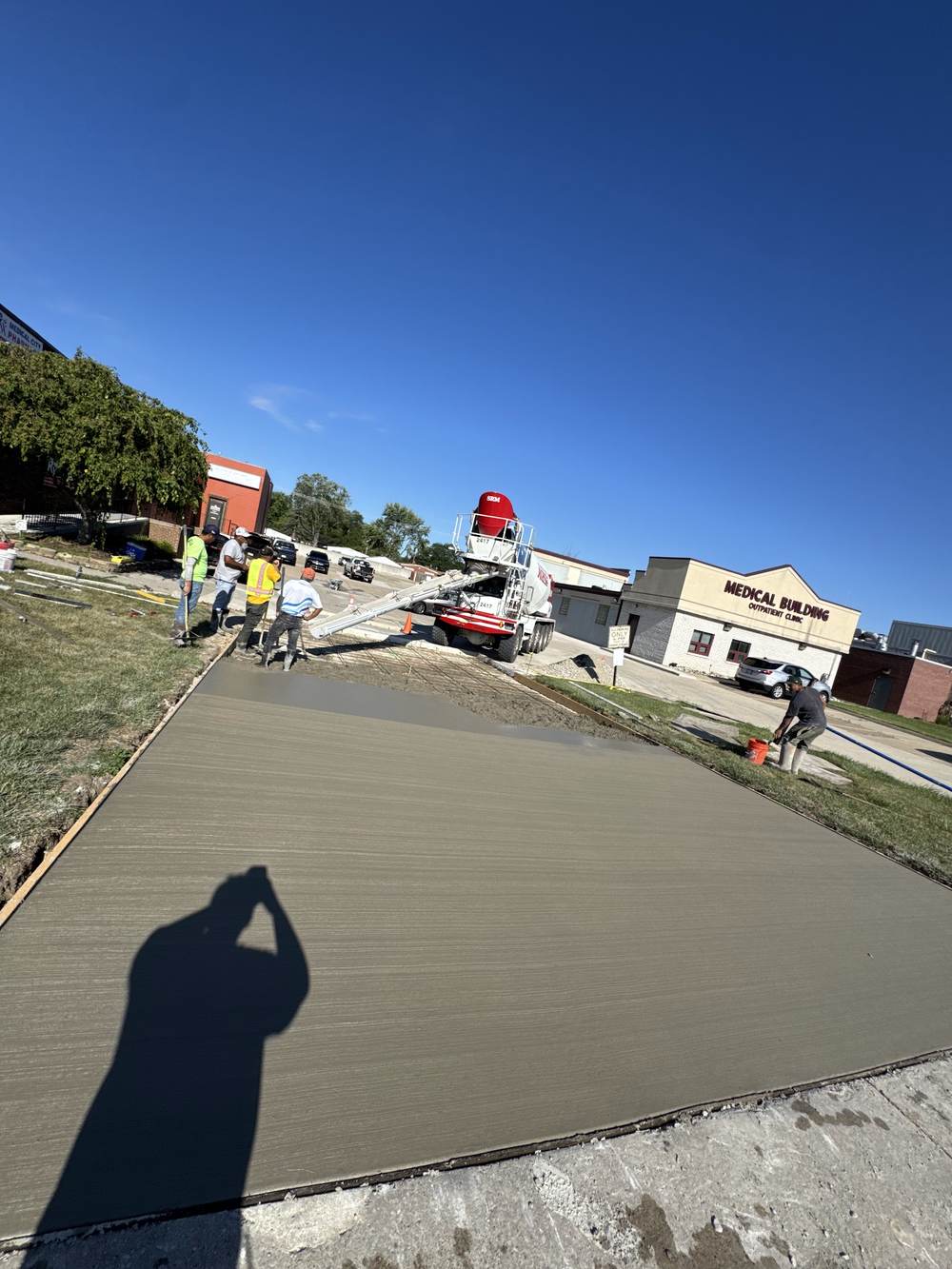 Ready-mix truck pouring while the crew screeds a fresh slab